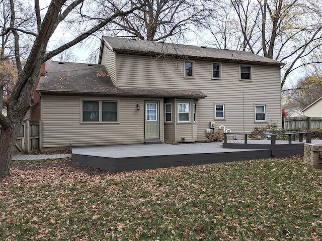 back of house featuring a wooden deck and a lawn