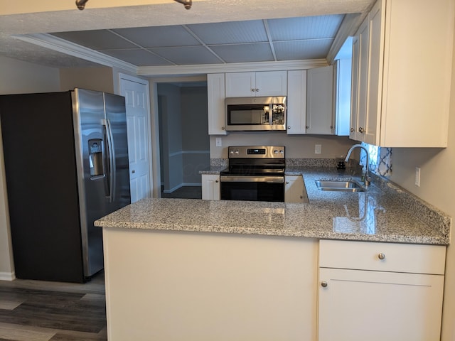 kitchen featuring light stone counters, appliances with stainless steel finishes, sink, and white cabinets