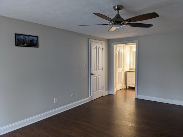 unfurnished room featuring dark wood-type flooring, ceiling fan, and a textured ceiling