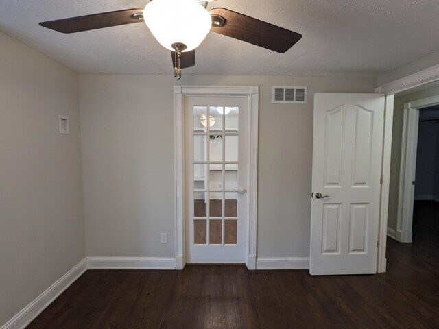 unfurnished room with ceiling fan, dark hardwood / wood-style floors, and a textured ceiling