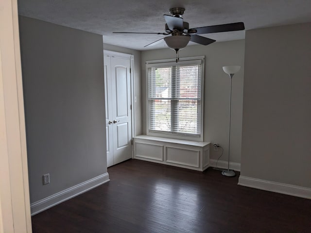 spare room with ceiling fan and dark hardwood / wood-style flooring