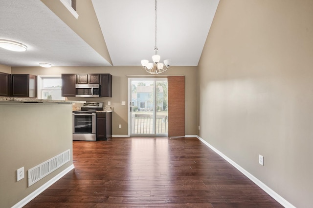 kitchen with hanging light fixtures, vaulted ceiling, dark brown cabinets, dark hardwood / wood-style flooring, and stainless steel appliances