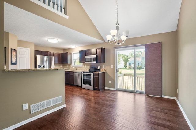 kitchen featuring appliances with stainless steel finishes, dark hardwood / wood-style floors, light stone counters, and a healthy amount of sunlight