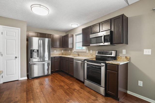 kitchen featuring dark brown cabinetry, dark hardwood / wood-style floors, and appliances with stainless steel finishes