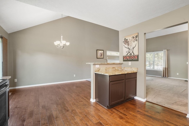 kitchen with pendant lighting, an inviting chandelier, light stone counters, and dark wood-type flooring