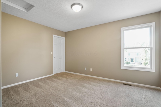 unfurnished room featuring carpet and a textured ceiling