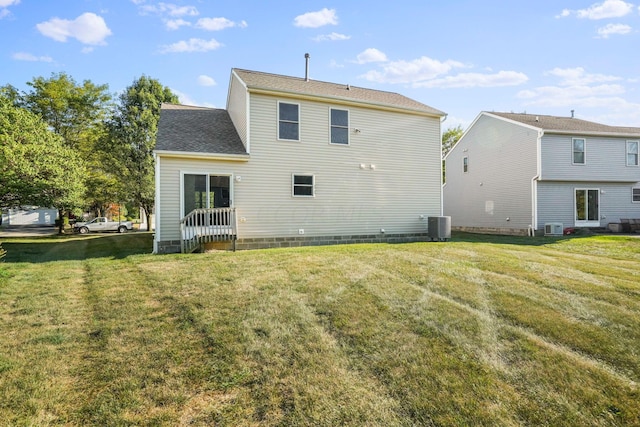 back of property featuring a lawn and central AC unit