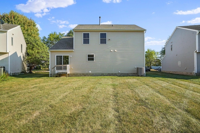 back of house featuring a lawn and central AC unit