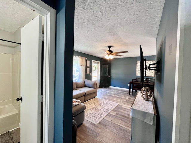 interior space with hardwood / wood-style floors, a textured ceiling, and ceiling fan