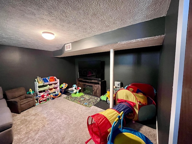 recreation room featuring carpet floors and a textured ceiling