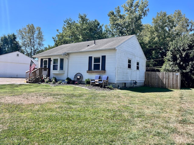 view of front of home featuring an outbuilding, a front yard, and a garage