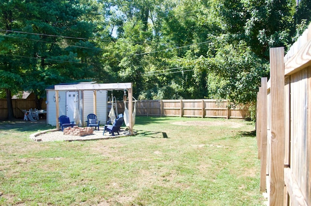 view of yard featuring a fire pit and a storage shed