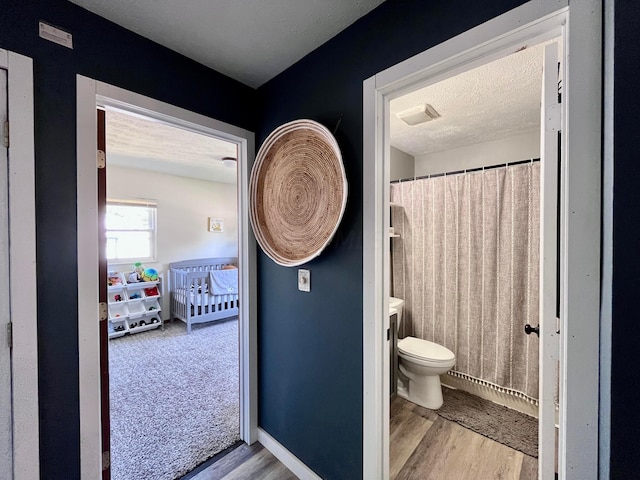 bathroom with hardwood / wood-style floors, vanity, toilet, and a textured ceiling