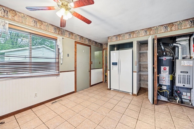 5010 Chipman Dr, Columbus, OH 43232 - below grade area with white refrigerator with ice dispenser, gas water heater, a ceiling fan, light tile patterned floors, and wainscoting
