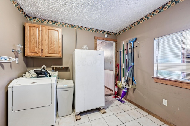 5010 Chipman Dr, Columbus, OH 43232 - laundry area with cabinet space, a textured ceiling, light tile patterned floors, and baseboards