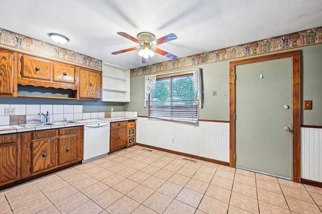 5010 Chipman Dr, Columbus, OH 43232 - kitchen with white dishwasher, tile counters, a sink, brown cabinets, and a wainscoted wall