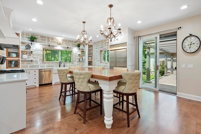 dining area featuring an inviting chandelier, recessed lighting, wood finished floors, and a wealth of natural light