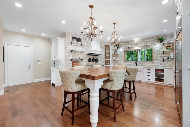 kitchen featuring open shelves, wood counters, a chandelier, and a kitchen bar