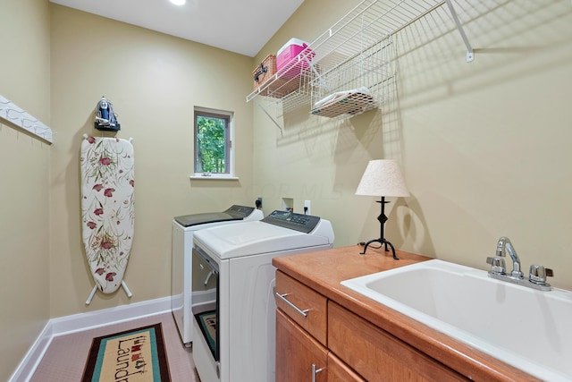 laundry area featuring washing machine and clothes dryer, cabinet space, a sink, baseboards, and carpet floors