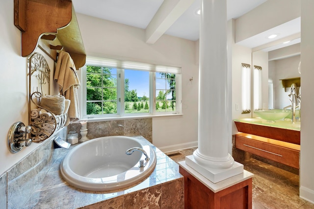 full bath featuring vanity, decorative columns, and a bath