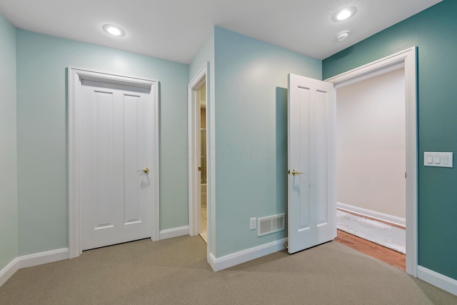 unfurnished bedroom with carpet flooring, recessed lighting, baseboards, and visible vents