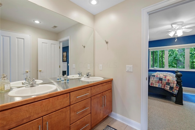 ensuite bathroom with a sink, baseboards, ensuite bathroom, and ceiling fan