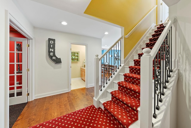 foyer with recessed lighting, baseboards, stairs, and wood finished floors