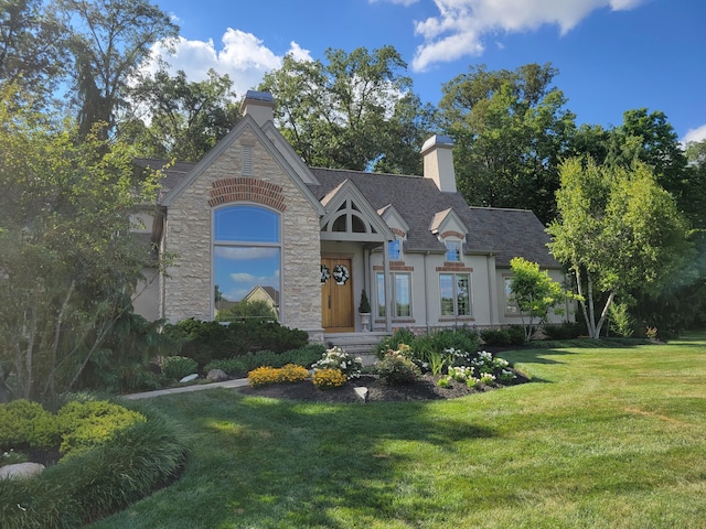 view of front facade with stucco siding, a chimney, stone siding, and a front lawn