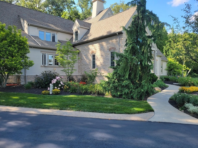 view of property exterior featuring stucco siding, stone siding, and a chimney