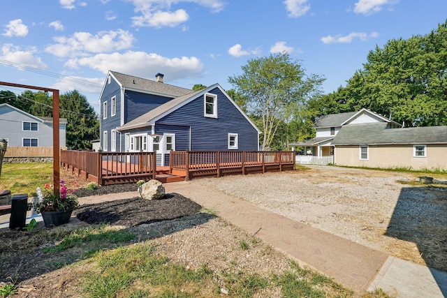 rear view of house featuring a wooden deck