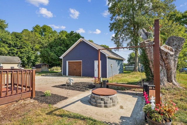 view of patio / terrace featuring a fire pit, a garage, a shed, and a deck