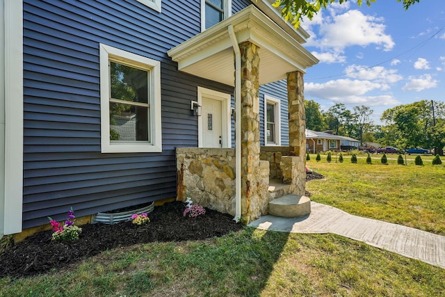 doorway to property featuring a lawn