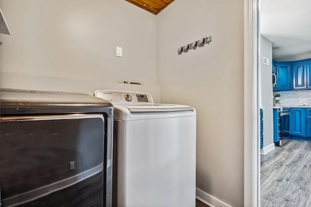 laundry room with light hardwood / wood-style flooring and washer and clothes dryer