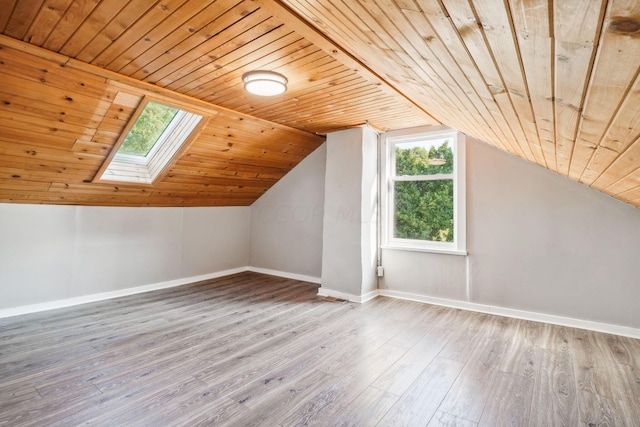 additional living space with lofted ceiling with skylight, hardwood / wood-style floors, and wooden ceiling