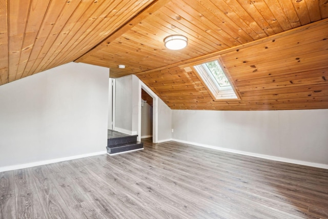 additional living space with wood-type flooring, lofted ceiling with skylight, and wood ceiling