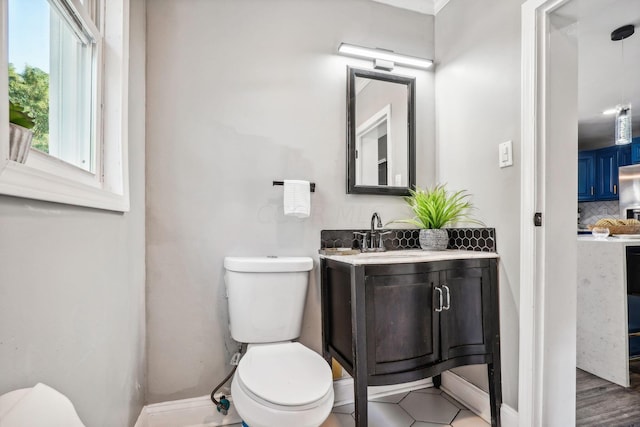 bathroom with hardwood / wood-style flooring, vanity, toilet, and decorative backsplash