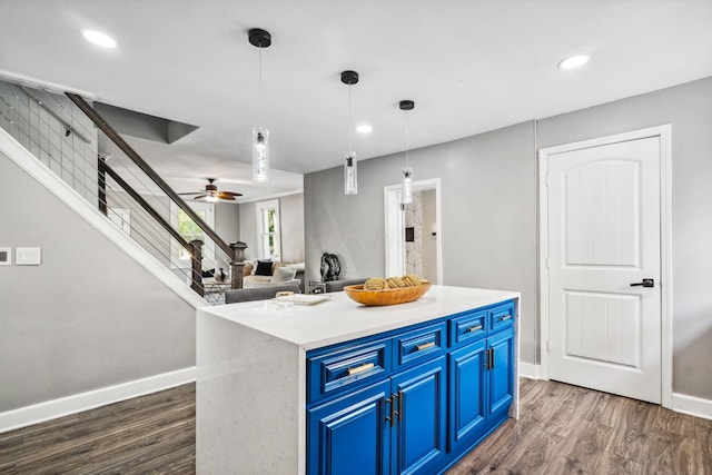 kitchen featuring blue cabinetry, pendant lighting, a kitchen island, and dark wood-type flooring