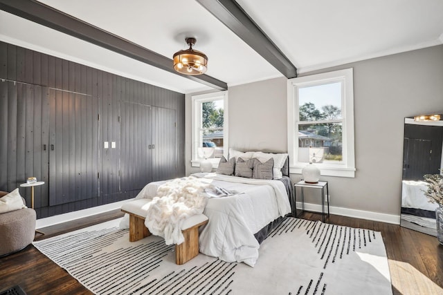 bedroom featuring beamed ceiling, ornamental molding, and hardwood / wood-style flooring