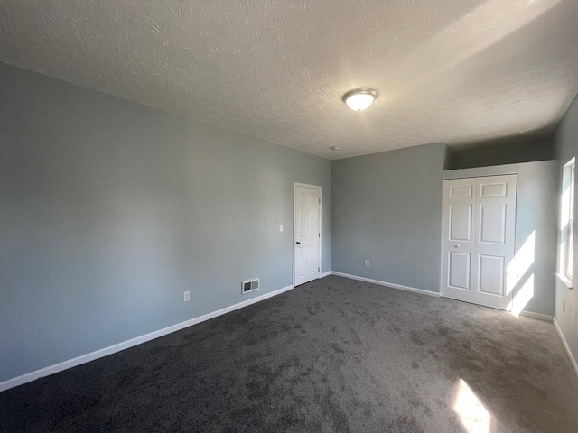 unfurnished room with carpet floors and a textured ceiling