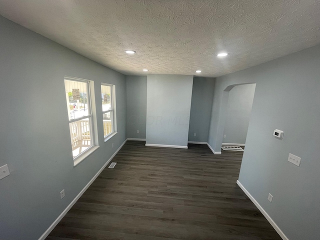 spare room with dark hardwood / wood-style flooring and a textured ceiling