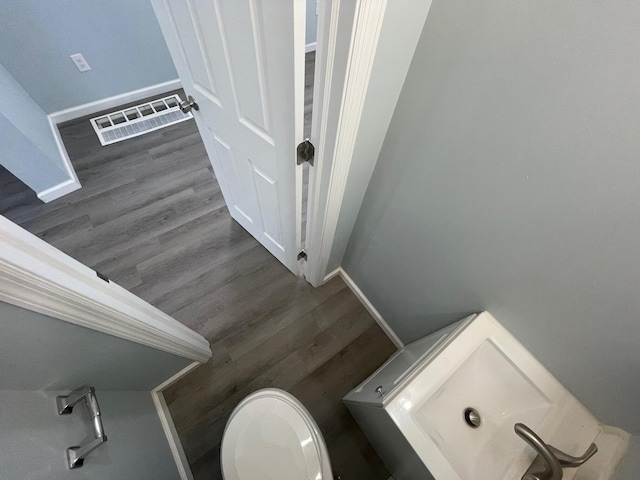 bathroom with hardwood / wood-style floors, toilet, and sink