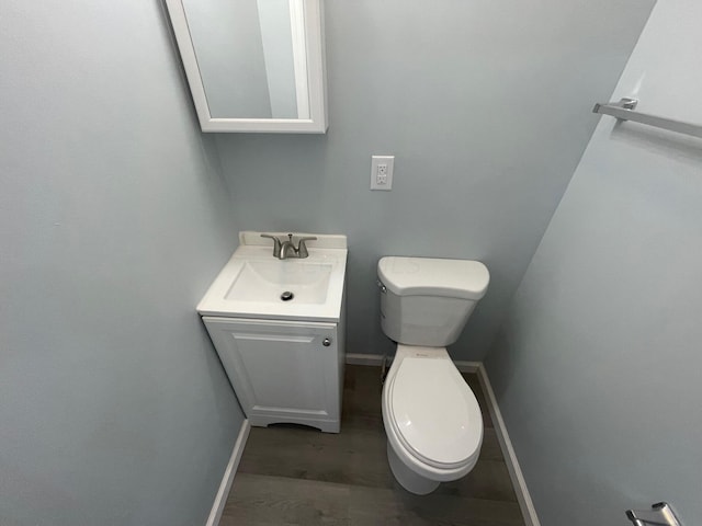 bathroom featuring toilet, vanity, and hardwood / wood-style flooring