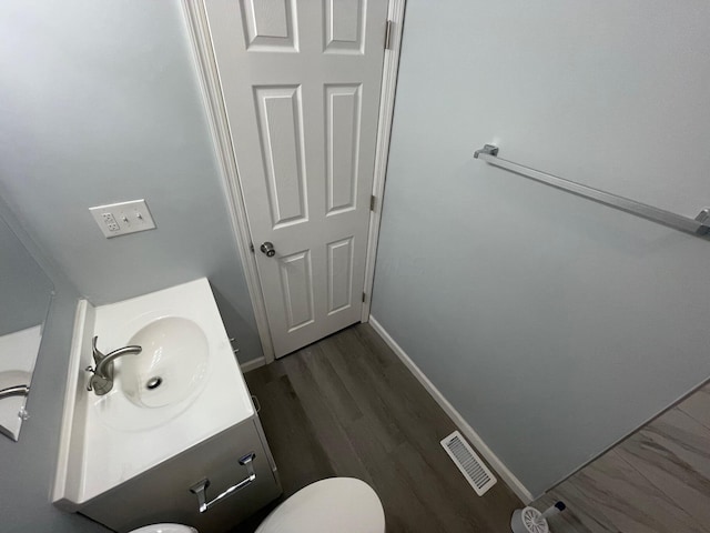 bathroom featuring vanity, toilet, and wood-type flooring