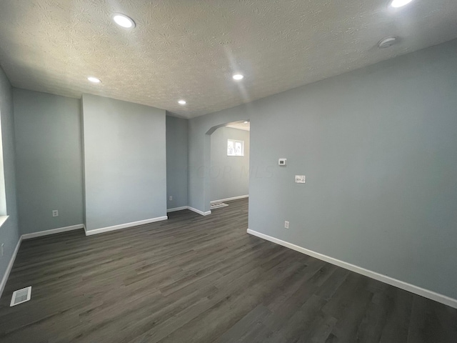 unfurnished room featuring dark hardwood / wood-style flooring and a textured ceiling