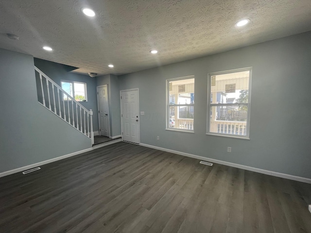 entryway featuring plenty of natural light, dark wood-type flooring, and a textured ceiling