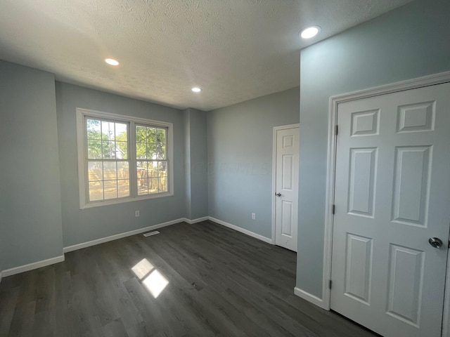 unfurnished bedroom featuring dark hardwood / wood-style floors and a textured ceiling