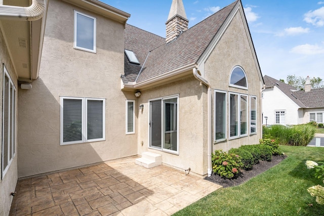 back of house with a patio area and a lawn