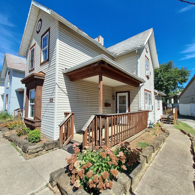 view of front of property with cooling unit and a porch