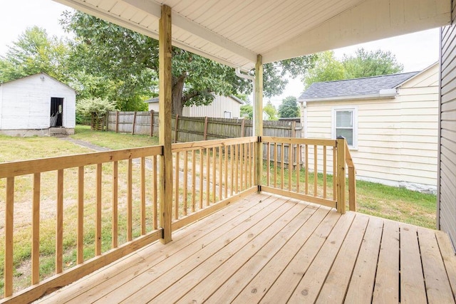 wooden terrace featuring a lawn and an outdoor structure