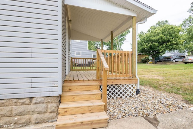 wooden terrace with a lawn and covered porch